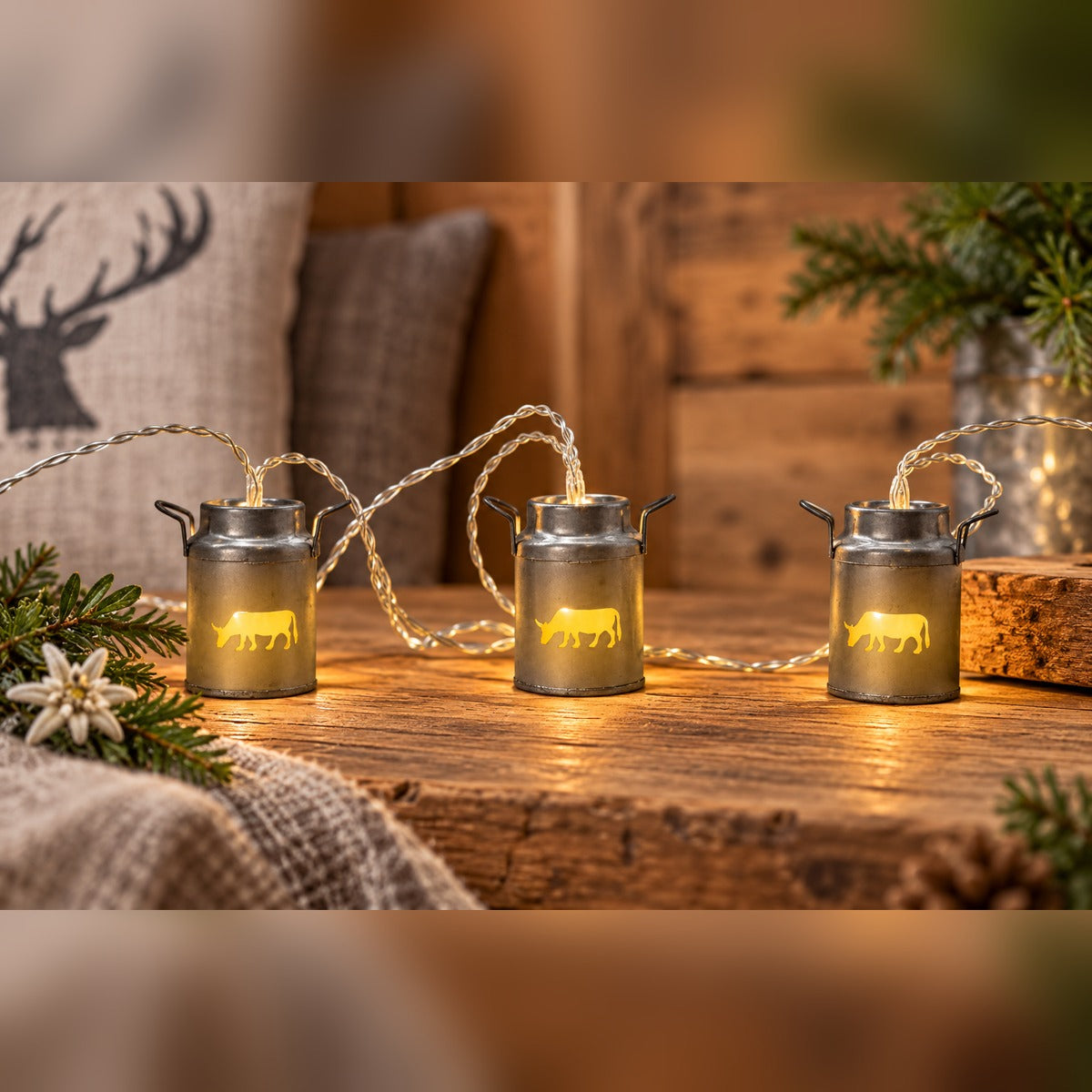 Milchkannen-Lichterkette mit leuchtender Kuh auf rustikalem Holz